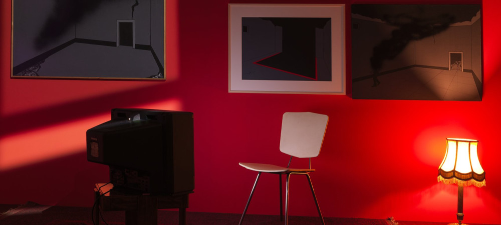 rdeca soba z belim stolom in slikami na stenah