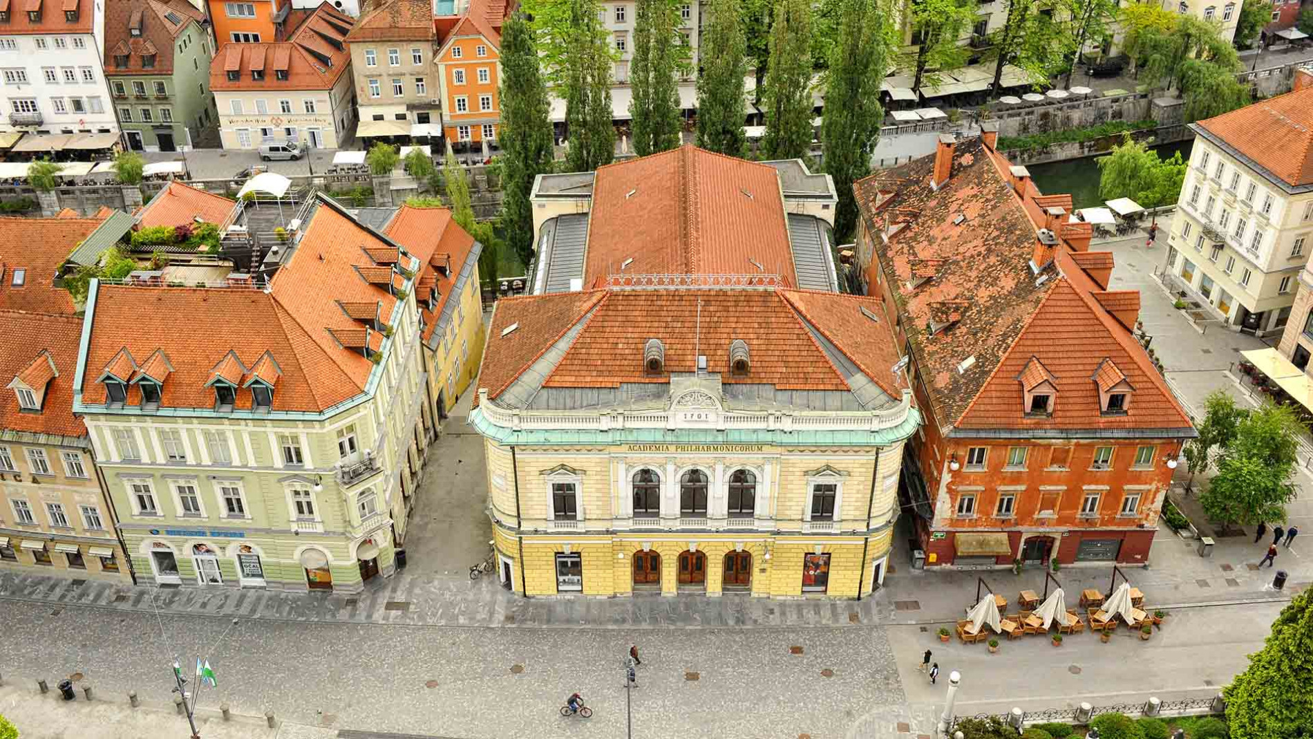 Panoramski pogled na filharmonijo z Ljubljanico v ozadju.