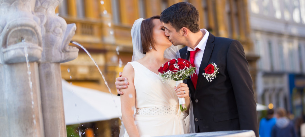 The newlyweds kiss in front of the fountain on Gornji trg.