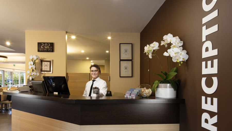 Recepcija z usluzbenko v belem.