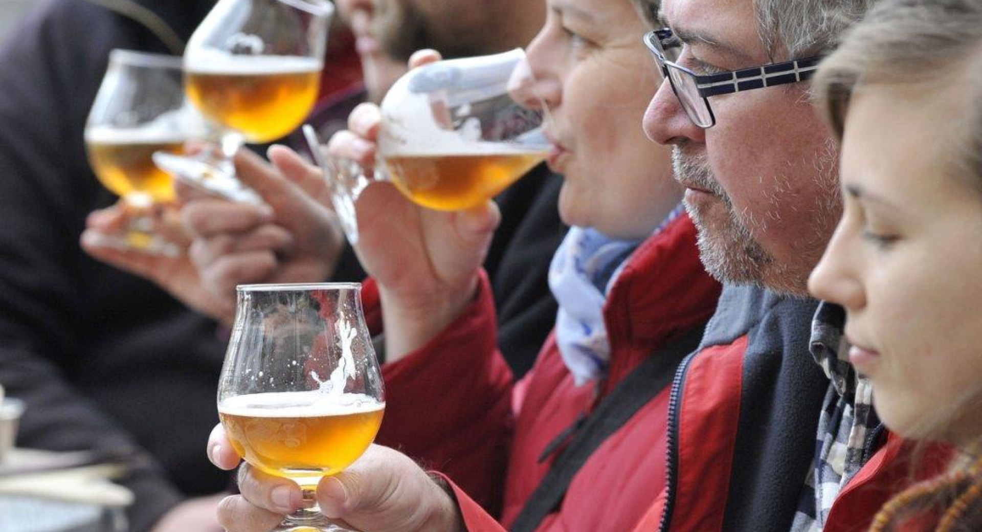 Skupina ljudi pije pivo.