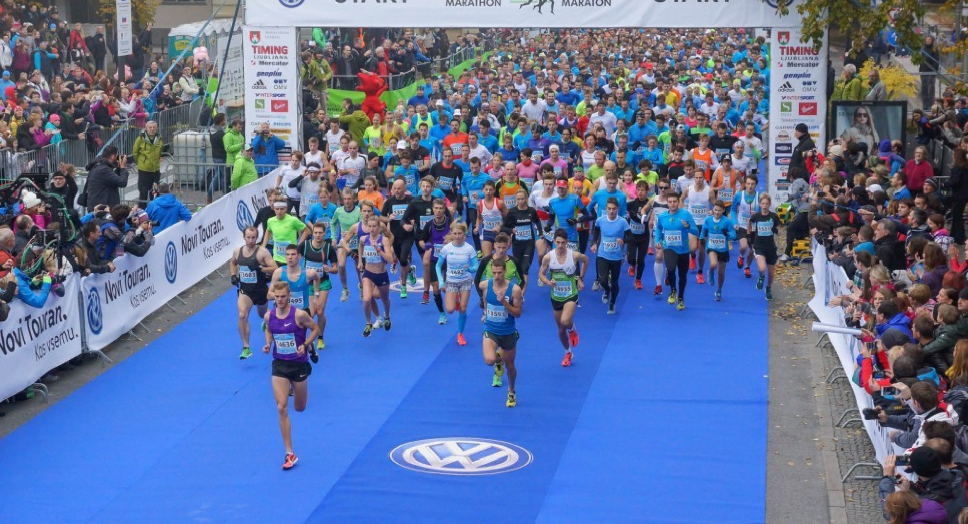 Maraton. Na levi in desni strani navijači.