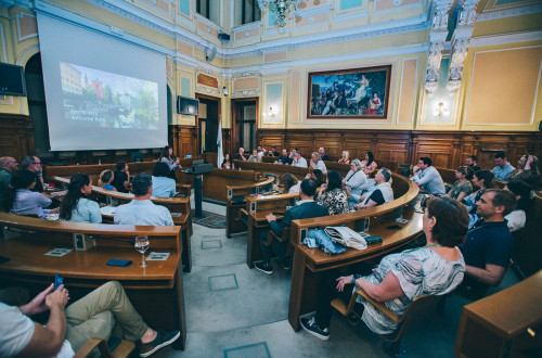 Udeleženci mednarodnega dogodka SITE Incentive Summit Europe 2023 v ljubljanski Mestni hiši; na platnu fotografija Ljubljane, pred njo govornica in občinstvo