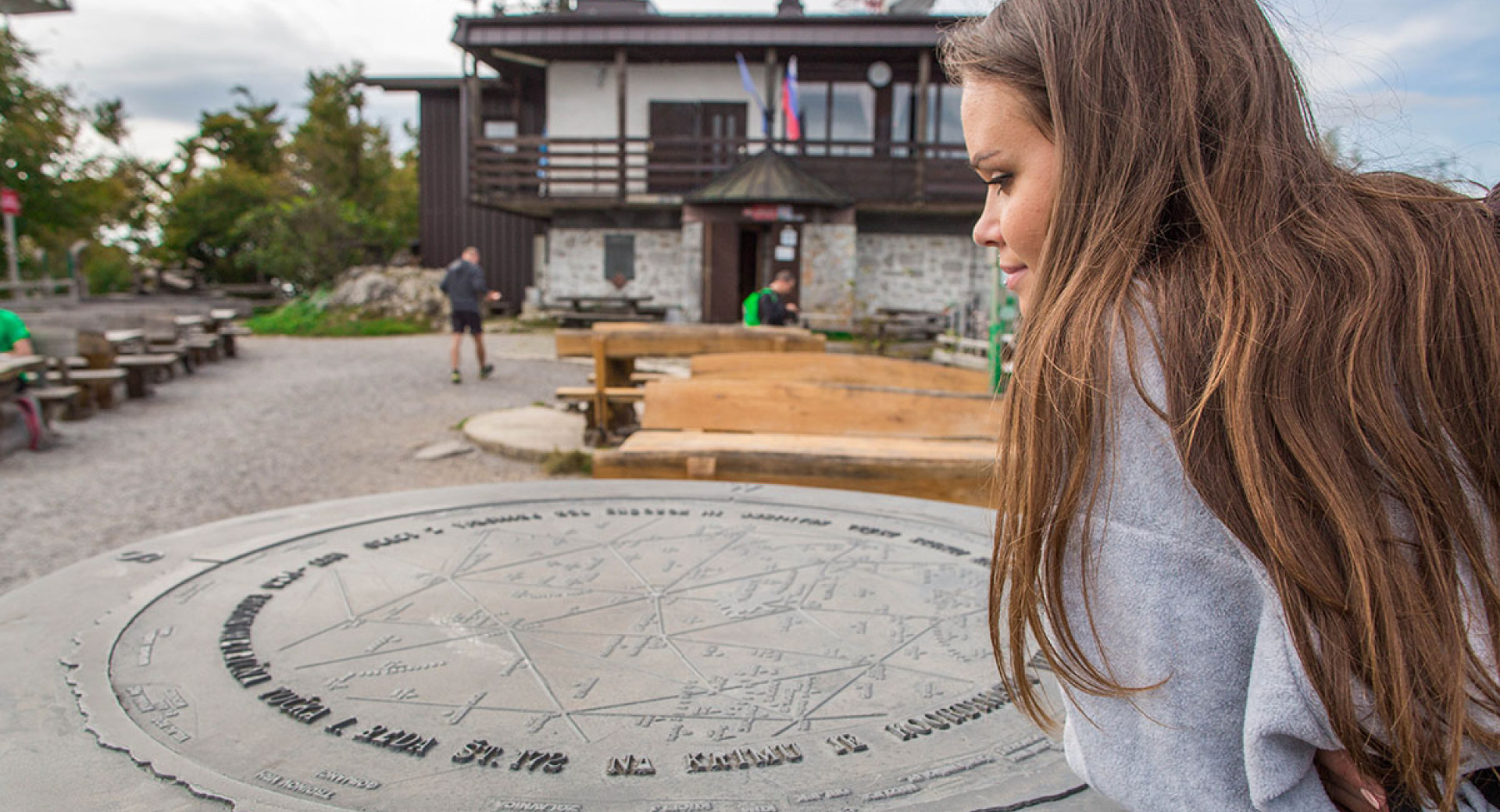 Pohodnica ob okrogli smerni plošči ob planinskem domu na Krimu nad Ljubljanskem barju