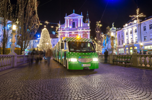 Mestni vlakec v ozadju okrašeno mesto