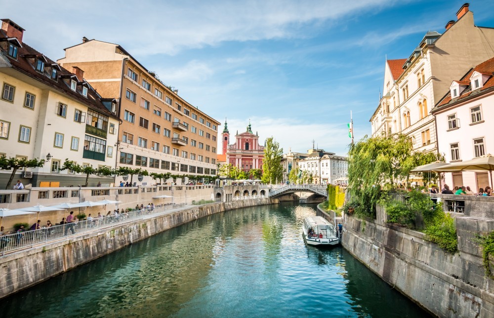 Ladjica na Ljubljanici. V ozadju Frančiškanska cerkev in Prešernov trg.