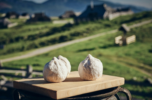 Trnič, znameniti sir z Velike planine; v ozadju Velika planina