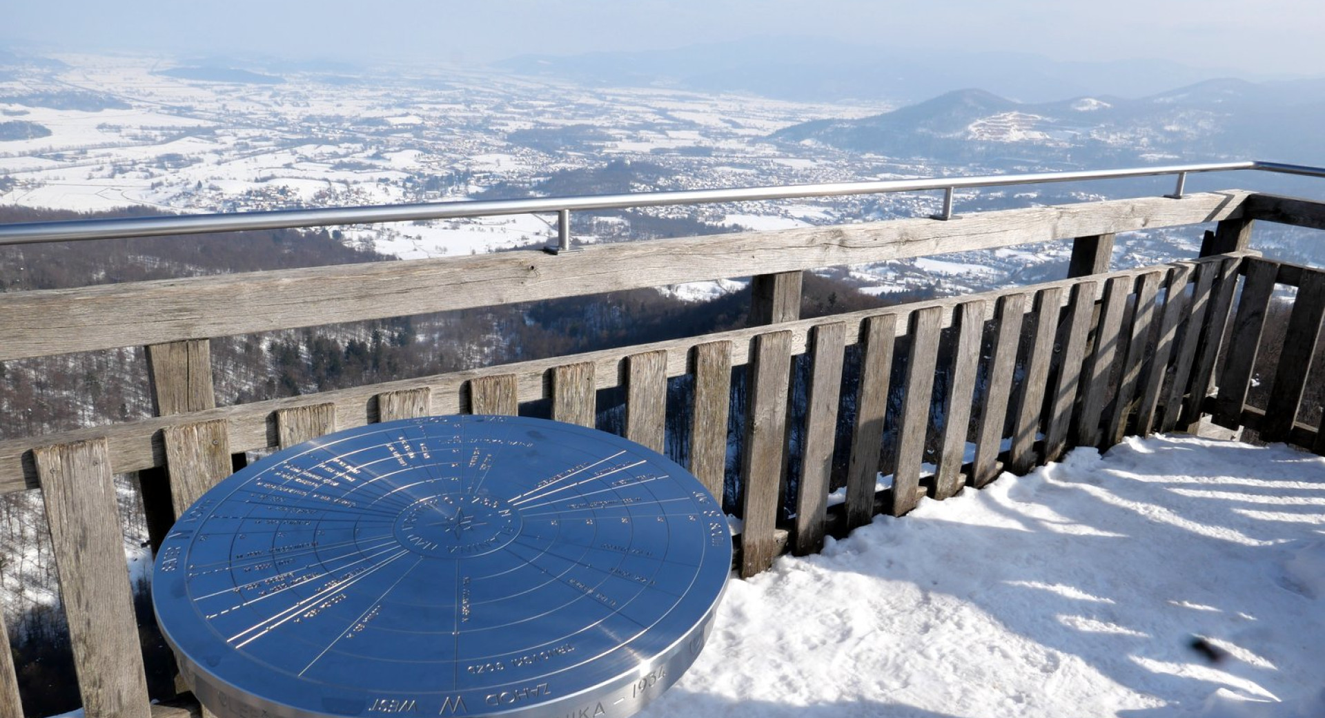 Na vrhu stolpa na Planini nad Vrhniko je okrogla smerna plošča, ki je v pomoč pri tolmačenju razgleda