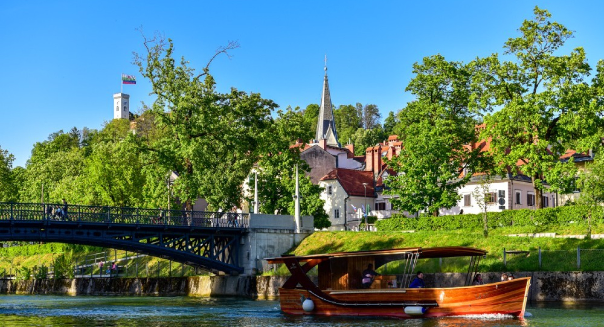 Ladjica na Ljubljanici. V ozadju Ljubljanski grad.