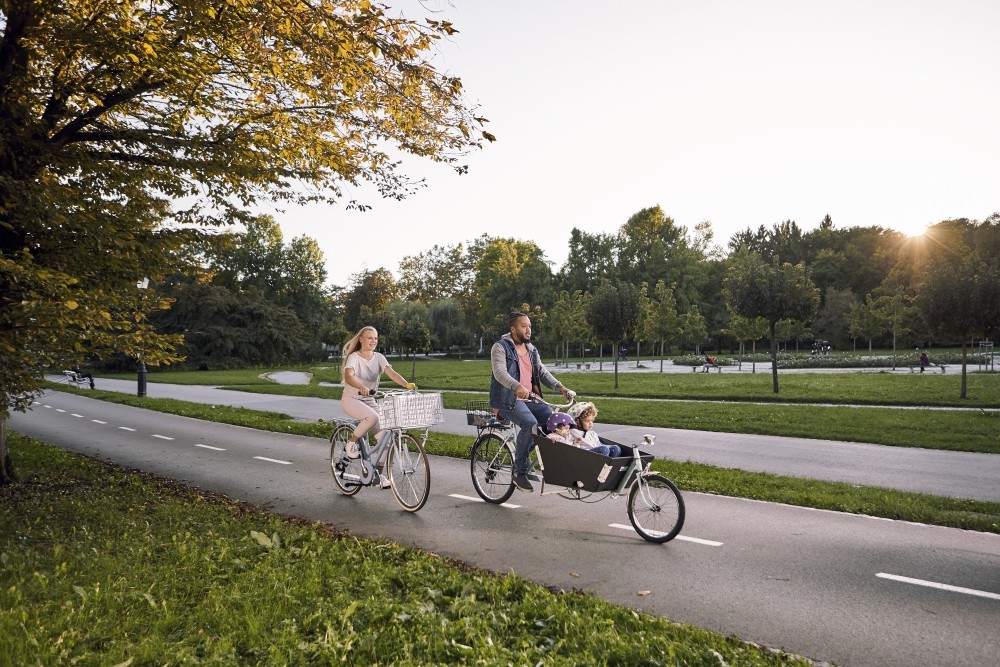 Družina kolesari v parku.