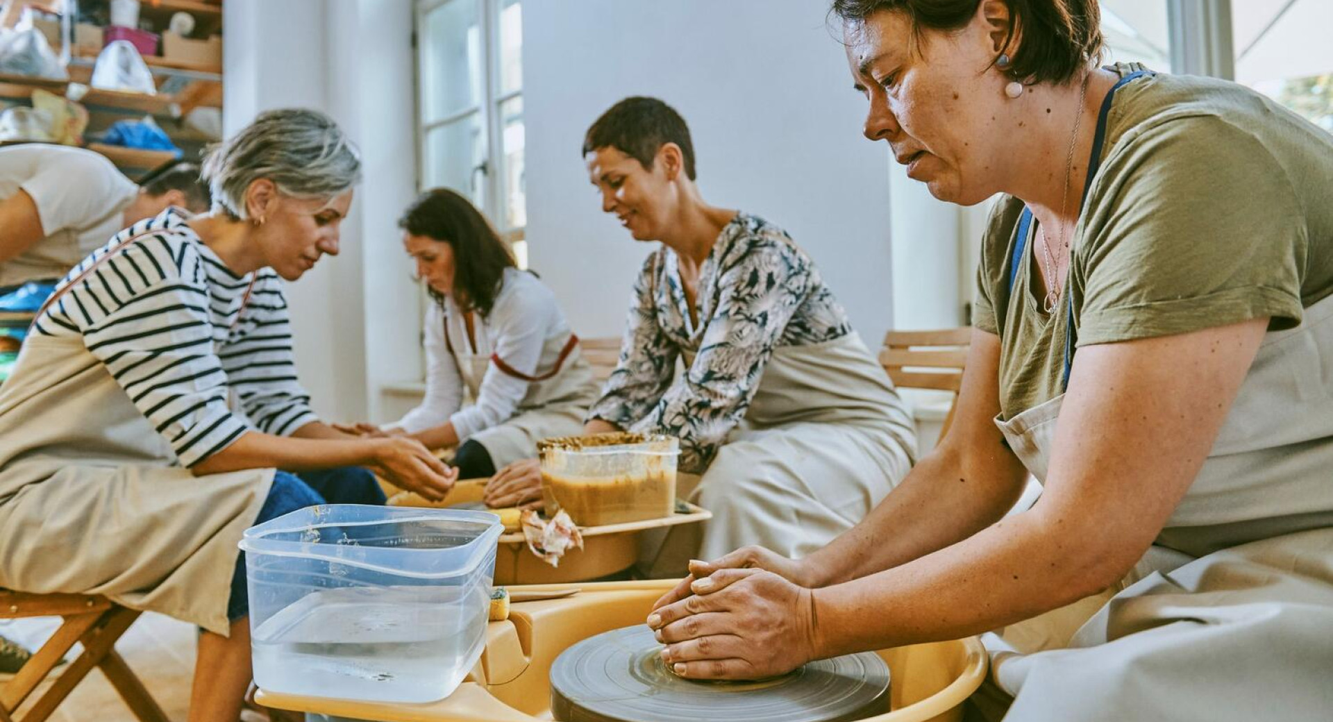 Več oseb oblikuje iz gline - doživetje ljubljanske tradicije lončarstva Igra v dvoje