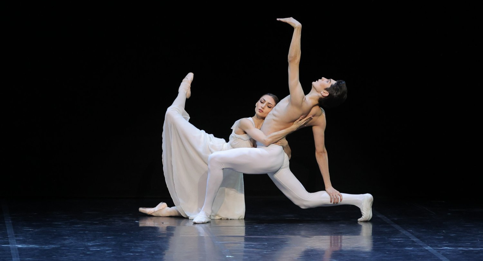 Baletnika, oblečena v belo, na odru – predstava Gala Balet Državnega opernega in baletnega gledališča v Astani, največje takšne institucije v Srednji Aziji