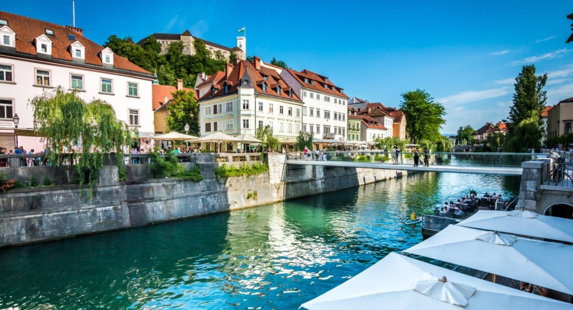 Meščanske hiše ob Ljubljanici. V ozadju je Ljubljanski grad.