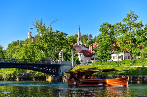 Ladjica na Ljubljanici. V ozadju Ljubljanski grad.