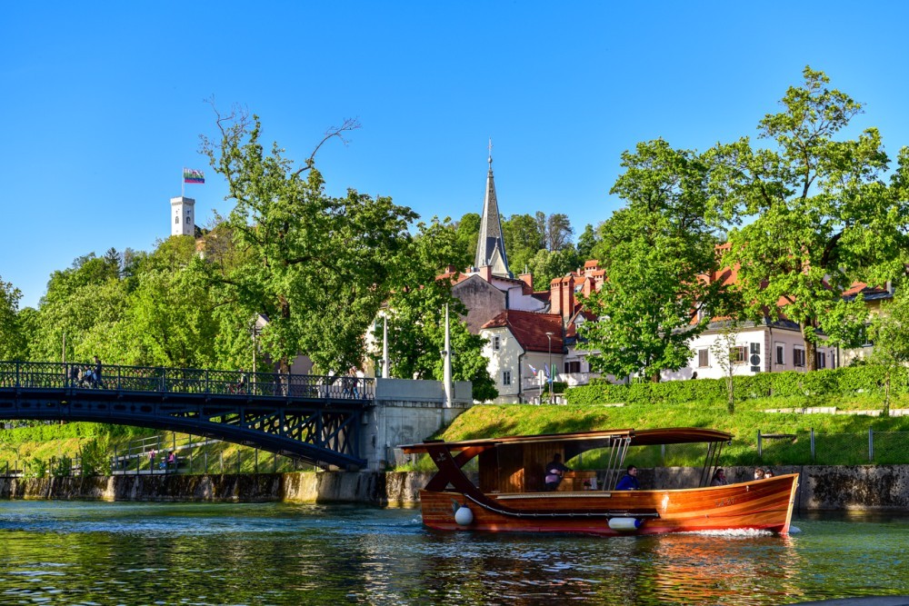 Ladjica na Ljubljanici. V ozadju Ljubljanski grad.