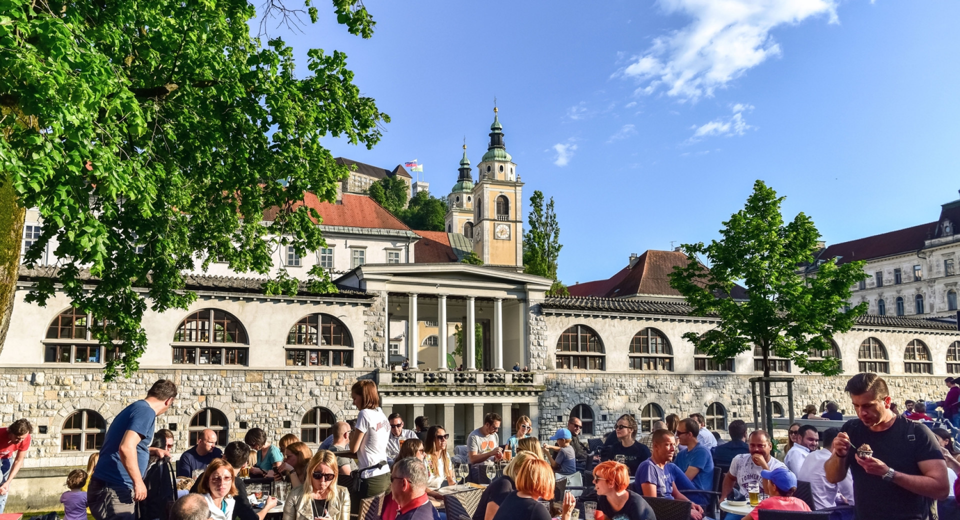 Polni gostinski vrtovi na nabrežju Ljubljanice; nasproti Plečnikove tržnice