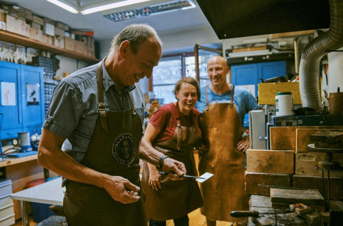 Visitors watch a master demonstrate the handmade production of silver jewelry.