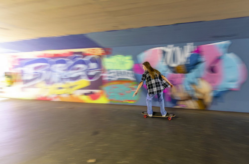 Dekle na rolki ob velikem grafitu v podhodu v Ljubljani