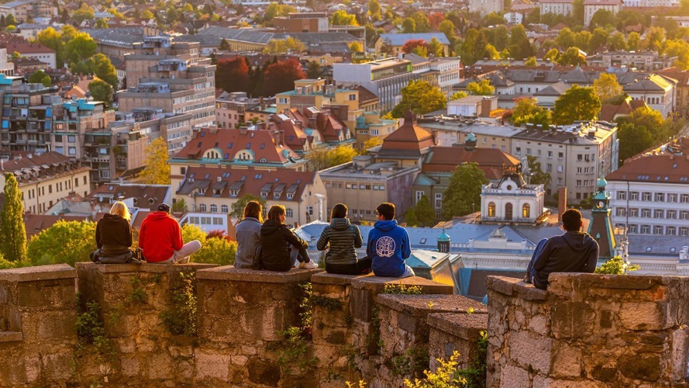 Ljudje na grajskem obzidju. Pod njimi Ljubljana.