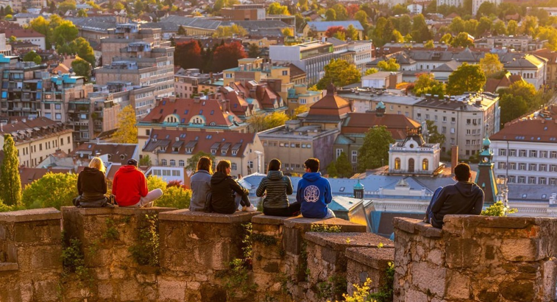 Ljudje na grajskem obzidju. Pod njimi Ljubljana.