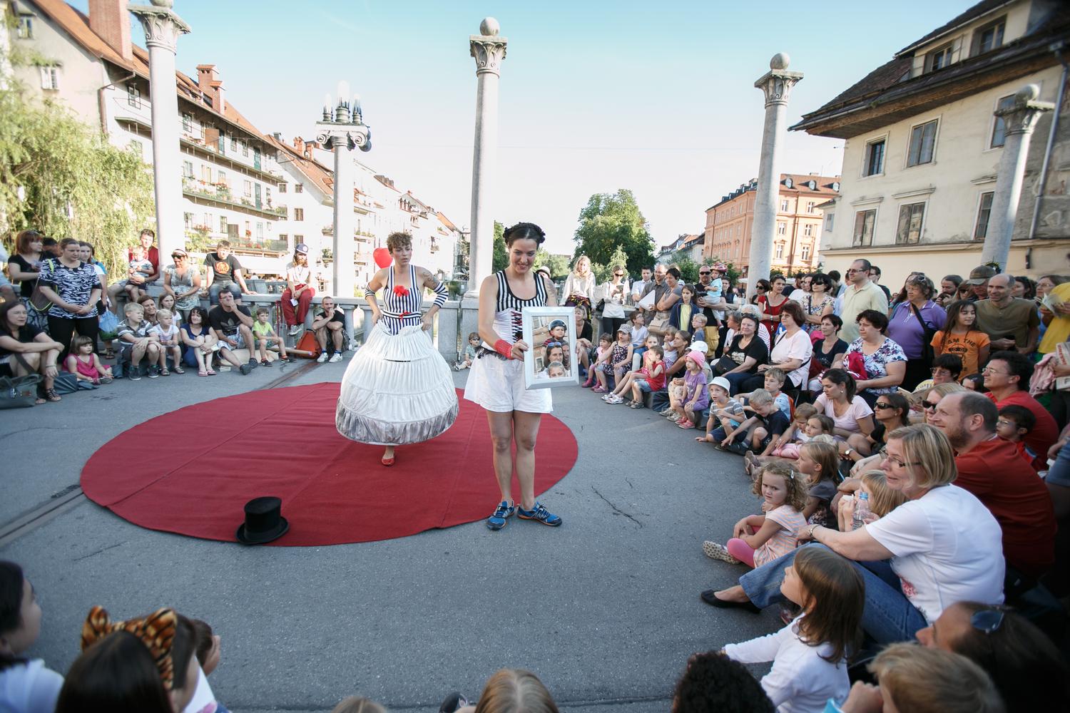 Predstava na Čevljarskem mostu. Okoli predstave gledalci.