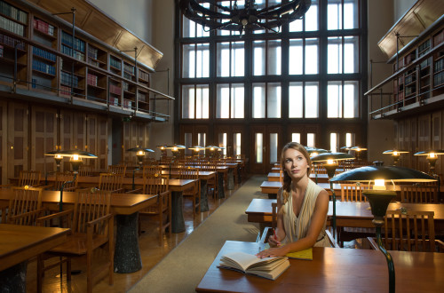 Notranjost narodne in univerzitetne knjižnice. V ospredju dekle s knjigo.