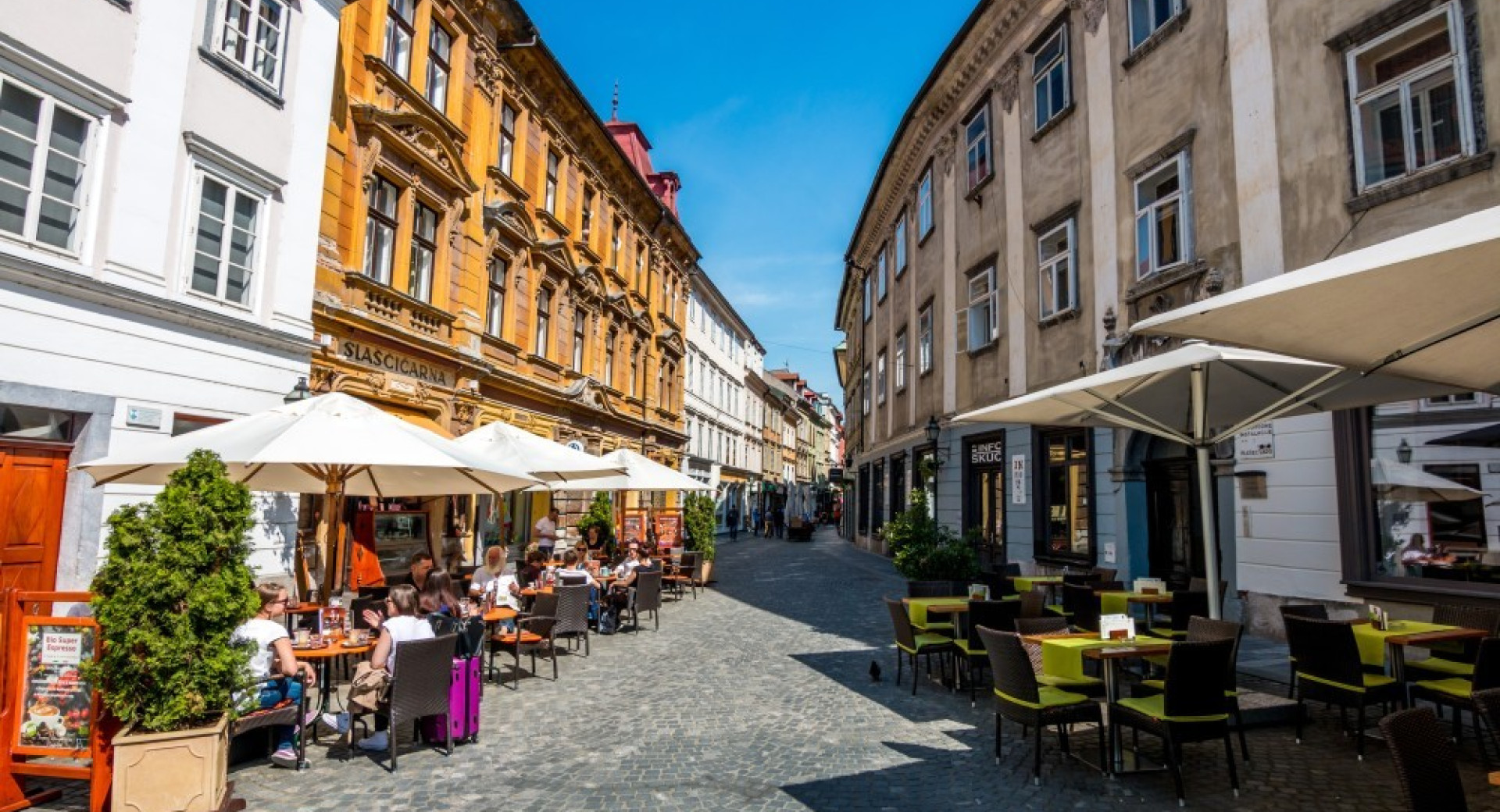 Zunanje terase z gosti v centru Ljubljane.