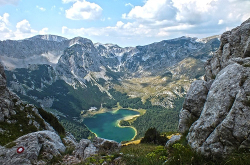 Jezero v obliki srca v objemu gora.