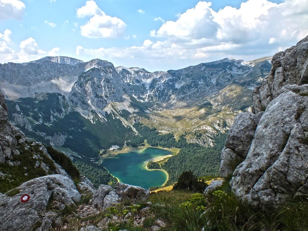 Jezero v obliki srca v objemu gora.