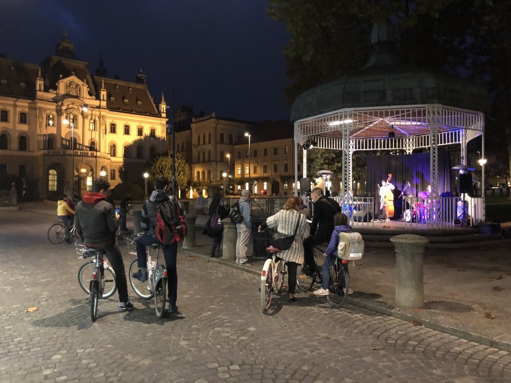 Gledalci poslušajo koncert na prostem v paviljonu na Kongresnem trgu.