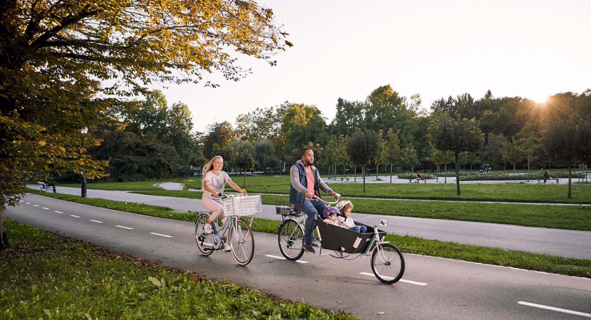 Par z majhnim otrokom kolesari v parku Tivoli v Ljubljani