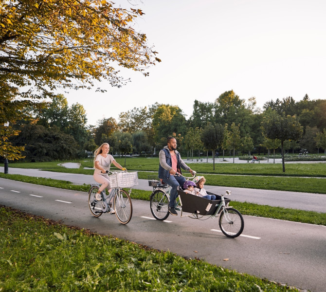 Par z majhnim otrokom kolesari v parku Tivoli v Ljubljani.