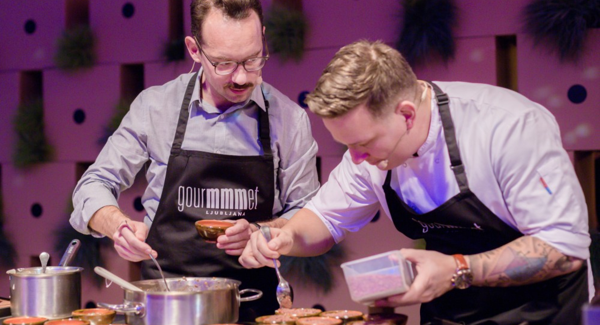 Chef Jorg Zupan pripravlja krožnike. Ob njem pomočnik.