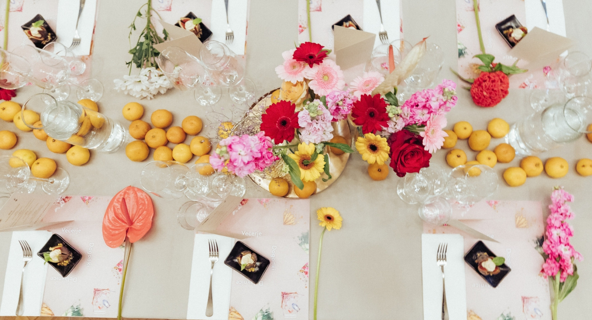 Z mandarinami in cvetjem okrašena pogrnjena miza