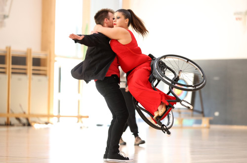 Moški in ženska plešeta - ženska je na invalidskem vozičku