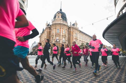 Tekači v Ljubljani v rožnatih majicah tečejo na Rožnatem maratonu, 2021
