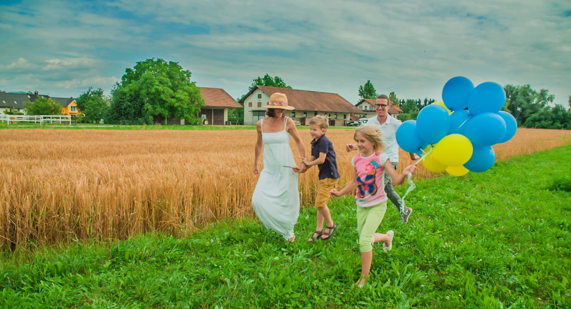 Srečna družina v igri ob žitnem polju.