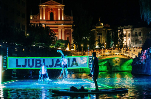 Igranje odbojke na osvetljenem igrišču na Ljubljanici v središču Ljubljane