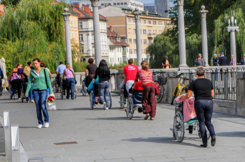 Mestni utrip - sprehajalci na invalidskih vozičkih s spremljevalci.