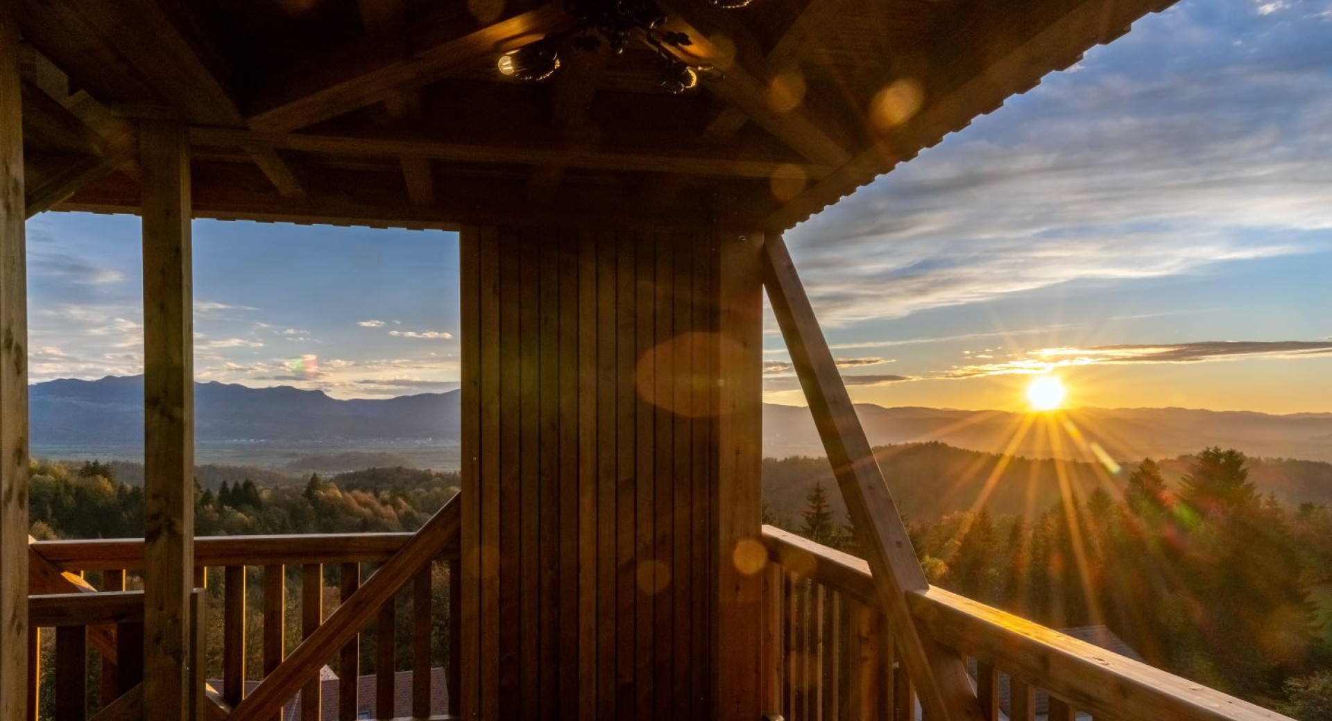 Interior of a wooden observation tower with a view of the sunset.