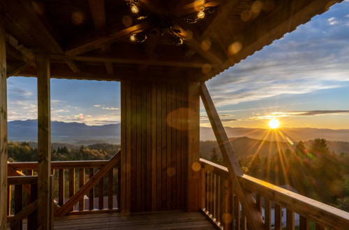 Interior of a wooden observation tower with a view of the sunset.
