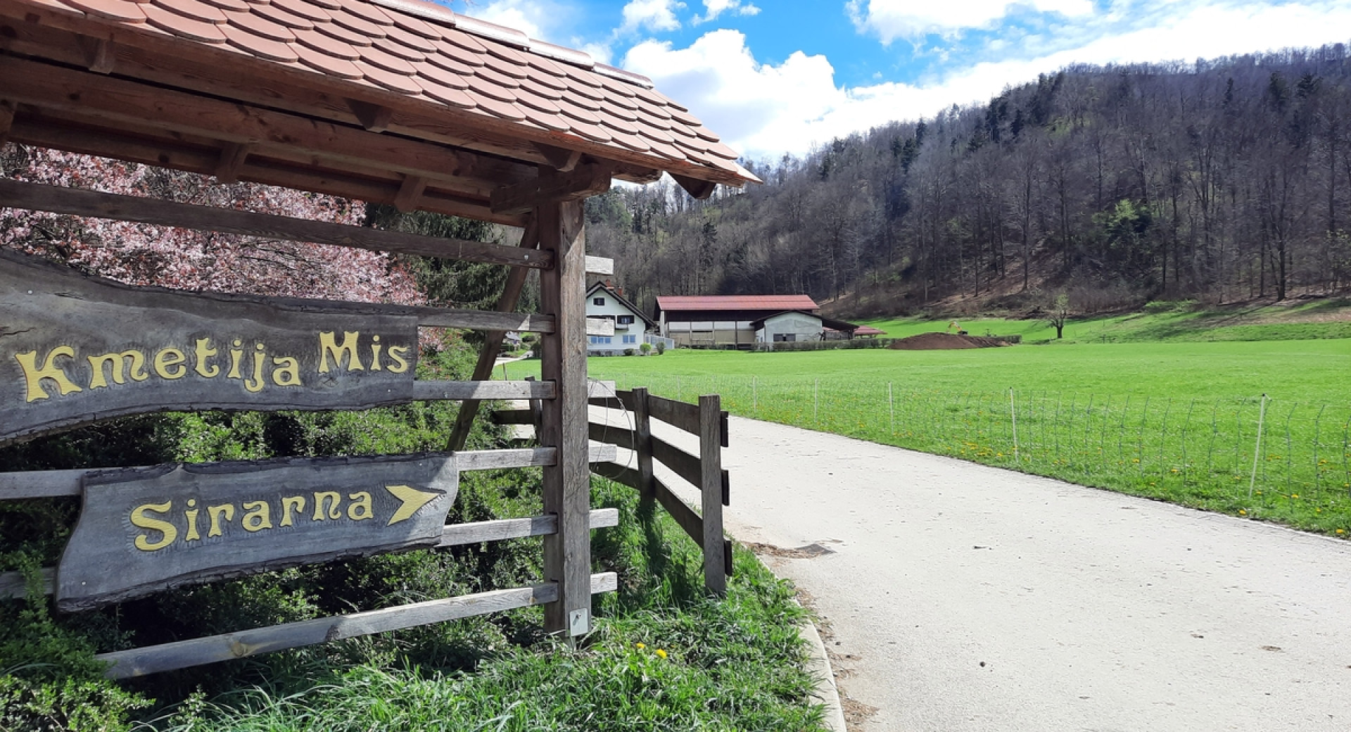 Ein hölzerner Heuschober mit dem Schild „Kmetija Miš, Sirarna.“