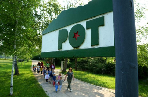 Velik napis Pot, v ozadnju pohodniki.