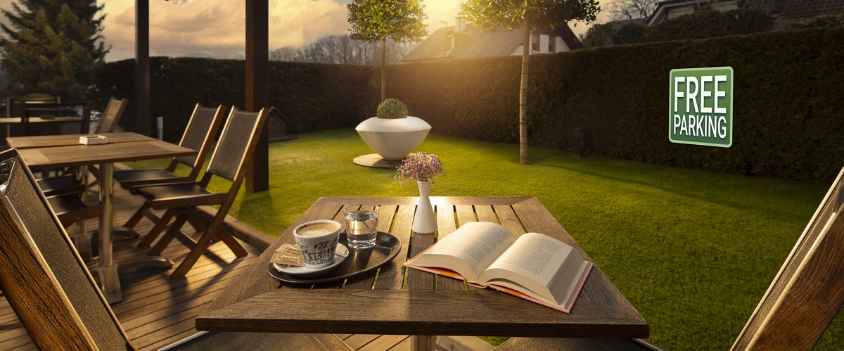 Wooden tables and chairs overlooking the greenery.