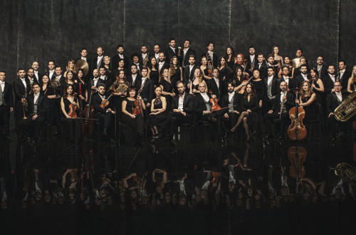 fotografija orkestra z instrumenti na sivem ozadju