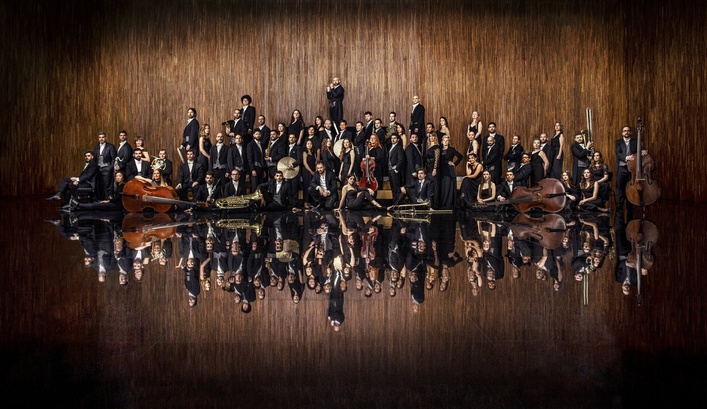 skupinska fotografija orkestra, rjavo leseno ozadje