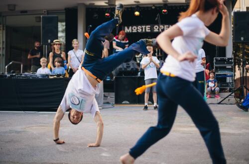 Ples na ulici, kjer moški izvaja break dance.
