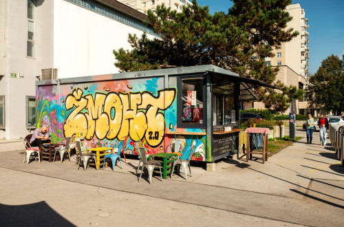 Barvit ulicni bistro s pisanimi grafiti in zunanjo teraso ponuja sprosceno urbano vzdusje za malico in druzenje.