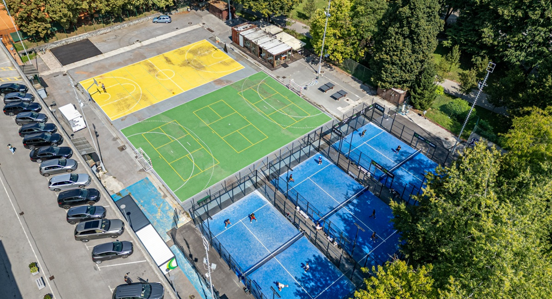 Three different sports courts surrounded by greenery.