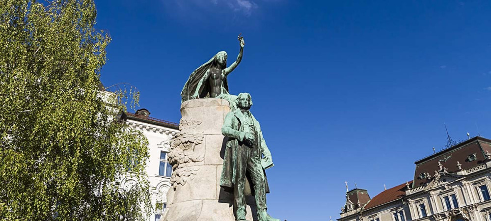 Spomenik pesniku, nad njim muza z oljcno vejico v roki.